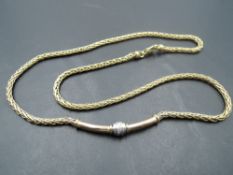 A yellow metal necklace having central panel with diamond chip decoration, no marks, tests as 9ct