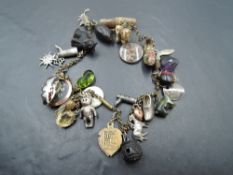 A gilt metal charm bracelet/necklace, suspended with a variety of charms, to include a bog oak