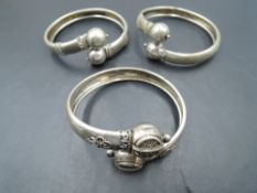 A trio of Oriental white metal tension bangles, all having ball tips, thought to be a mid 19th