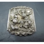 A white metal brooch having repousse decoration of a couple of Siam dancers, no marks tests as