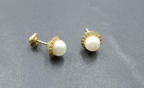 A pair of cultured pearl yellow metal stud earrings stamped 18 having screw on butterfly backs,