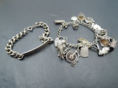 A white metal charm bracelet having eighteen HM silver and white metal charms including penny