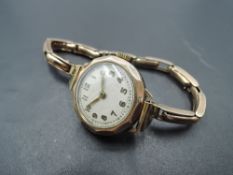 A vintage 9ct gold wrist watch having Arabic numeral dial with gilt minute dots to circular white