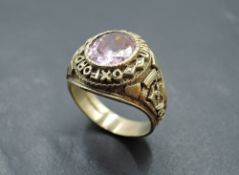 A 9ct gold Oxford University Graduation signet ring having central oval pink gem stone in a collared