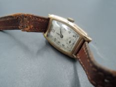 A 1930's 9ct gold wrist watch having Arabic numeral dial to rectangular face in 9ct rose gold case