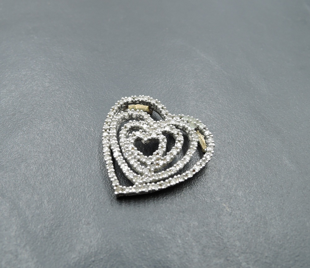 A 9ct white and yellow gold pendant of open heart shaped form having...