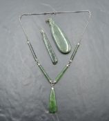 Three pieces of New Zealand greenstone jewellery including a necklace having greenstone panels