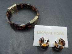 A Michael Kors tortoise shell coloured bangle with matching hoop earrings having diamante