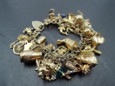 A 9ct gold fancy link charm bracelet having 42 yellow metal charms including Matador, Sydney Opera