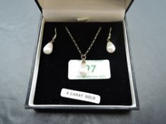 A 9ct gold and simulated teardrop pearl pendant and chain with matching drop loop earrings