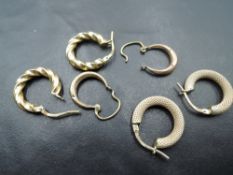 Three pairs of 9ct gold hoop earrings of different designs, approx 3g