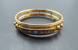 A Victorian yellow metal hinged bangle stamped 9ct having sapphire, diamond and seed pearl