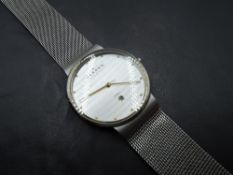 A Skagen wrist watch, no: 355LGSC having gilt dot dial and date aperture to silvered face on woven