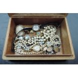 A small wooden jewellery box containing a small selection of costume jewellery including Ciro pearls