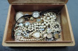 A small wooden jewellery box containing a small selection of costume jewellery including Ciro pearls
