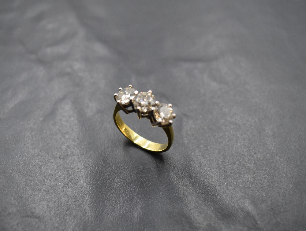 A diamond trilogy ring, total approx 2.20ct in a raised claw set mount on an 18ct gold loop, size