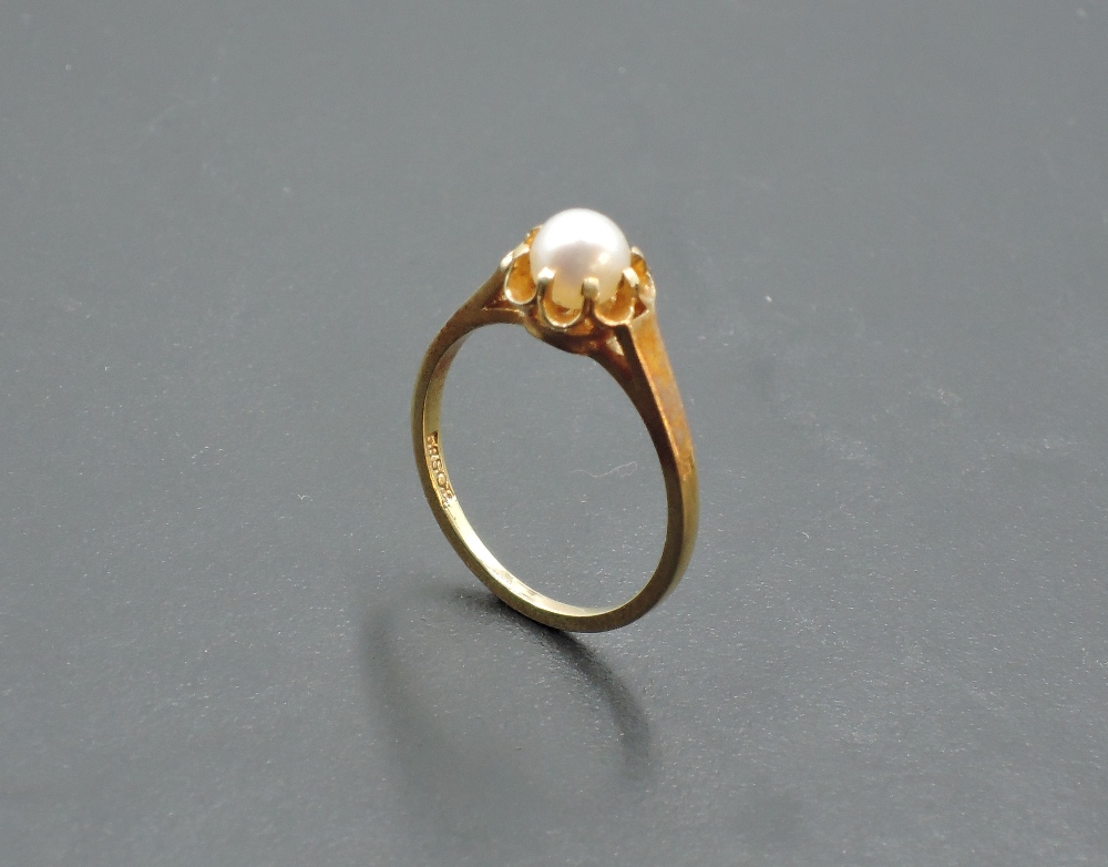 A cultured pearl solitaire ring in a frilled mount on a yellow metal loop stamped 585, size M &