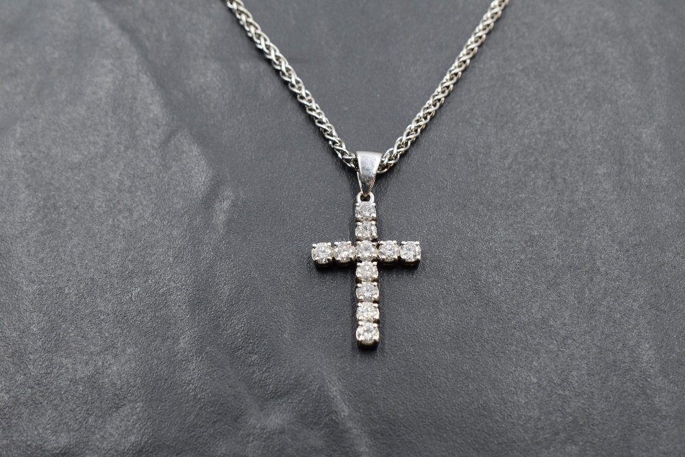 An eleven stone diamond cross pendant, total approx 0.75ct, in an 18ct white gold mount on a 9ct