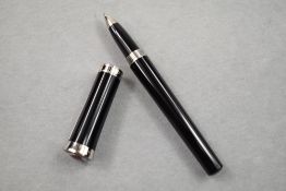 A Cartier Ballpoint pen having black barrel with silver cuff and faux ruby detail detail to top of