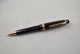 A Montblanc rollerball pen. The Montblanc Meisterstuck rollerball in black with rose gold trim.