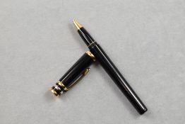 A Trois ors de Cartier Rollerball, having black barrel with gold and silver bands to cap, Number