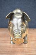 A vintage piggy bank of large size in brass approx 30cm tall and 50cm long.