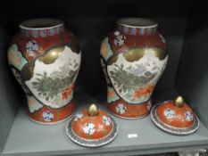 A substantial pair of 20th century Chinese porcelain lidded temple urns or jars decorated with peac