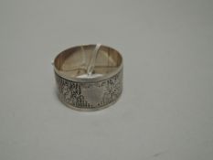 An Edwardian silver napkin ring, of circular form with geometric decoration and vacant shield-form