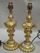 A pair of 20th century heavy cast brass lamps having cherub decorations