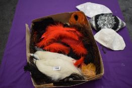 A box full of vintage and antique millinery feathers and similar items.