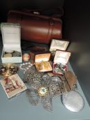 A tan coloured 1960s clasp top handbag and a selection of vintage costume jewellery, compacts and