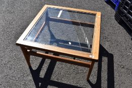 A vintage teak and glass top coffee table having stylised frame, approx 74 x 74cm