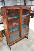 A late Victorian mahogany library book case having rolled glass doors on twist legs