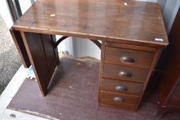 A vintage stained frame tailors/seamstress table having measure marks, drop flap and slide over four