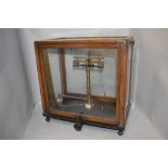 A set of Griffin and Tatlock Microid balance scales in glass and wood case.