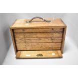 An oak cabinet makers chest of small proportions, having four drawers, leather carrying handle and