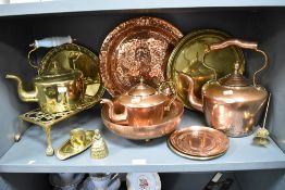 An assorted lot of vintage brass and copper ware, amongst which are trivets, kettles and chargers.