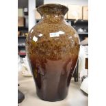 A substantial studio pottery lamp base having mottled brown glaze.