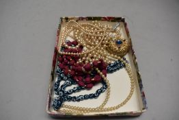 A collection of beads and a perfume bottle having filigree detail and blue gem stones.