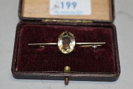 A white metal bar brooch stamped silver having a large central oval citrine of pale colour
