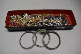 A lacquered glove box containing a selection of vintage and later costume jewellery including