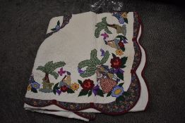 A 20th century American style bed quilt with hand sewn floral details and decals