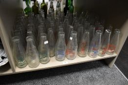 An array of vintage advertising milk bottles, many of local and surrounding area interest.