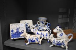A selection of Delft ware including milk jugs in the form of cows, vase and tiles.