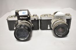 Two Nikon cameras a Nikkormat FT camera No FT3122842 with Nikkor 24mm 1;2,8 lens No 848590 and Nikon
