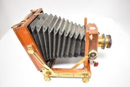 A Thornton Pickard mahogany case field camera having brass lens with two plate holders and cloth