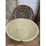 A large earthenware bowl and a glazed terracotta charger having floral pattern, both AF.