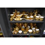 Two shelves of modern Royal Worcester porcelain tea wares having gilt glaze over porcelain