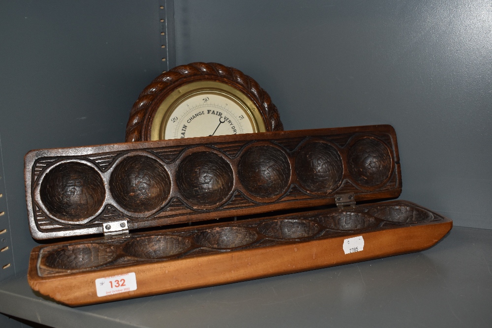 A carved wood ball holder or mould having carved decoration along with an Edwardian barometer