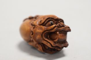 An early 20th century Japanese Netsuke carved as a double sided dragon